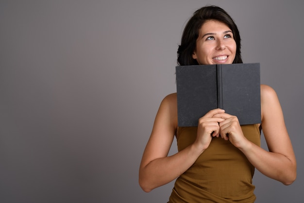 Young beautiful woman against gray background