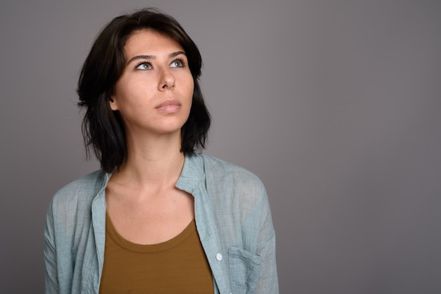 Foto giovane bella donna su sfondo grigio