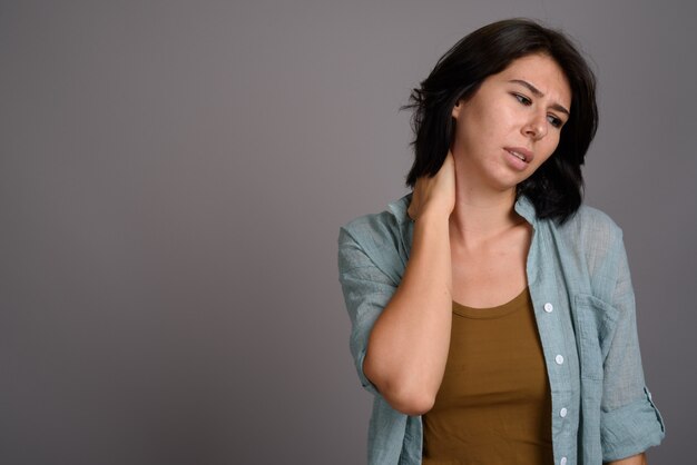 Young beautiful woman against gray background