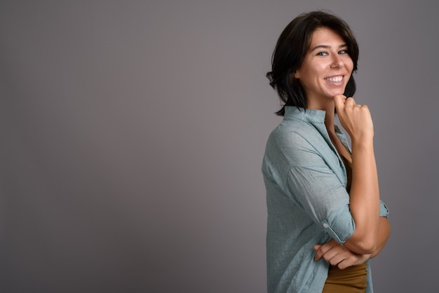 Young beautiful woman against gray background