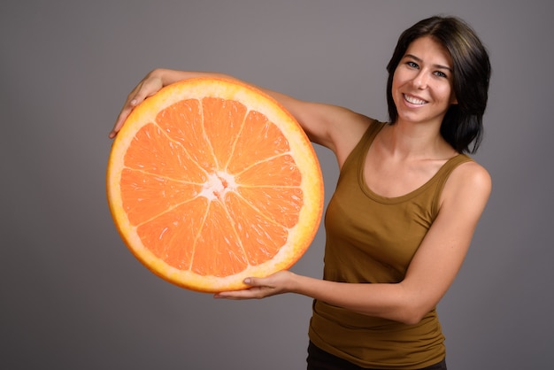 Foto giovane bella donna su sfondo grigio