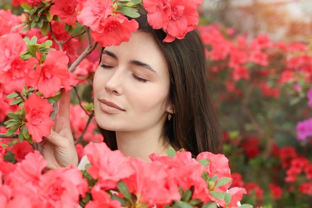 Giovane bella donna tra i fiori rosa, ritratto femminile