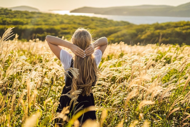 Молодая красивая женщина в осеннем пейзаже с сухими цветами колосья пшеницы Мода осень зима Солнечная осень мода фото