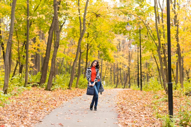 秋の公園で若い美しい女性