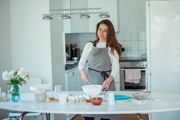 Young beautiful woman bakes a cake. Sweets. Confectionery.