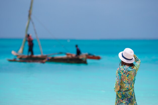 Foto giovane bella donna sulla spiaggia durante le vacanze tropicali