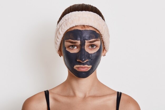 Young beautiful woman in black mud mask