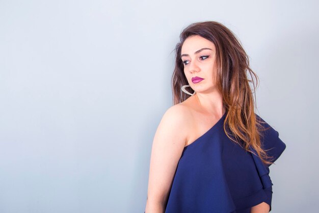 young beautiful woman in blue dress in studio