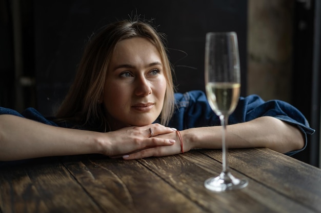 Young beautiful woman in a cafe, a woman drinking champagne in a cafe and talking.