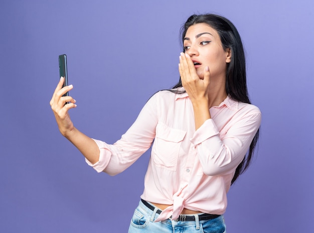 Giovane bella donna in abiti casual facendo selfie utilizzando smartphone felice e positivo che soffia un bacio