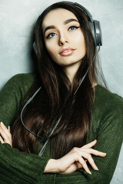 Young beautiful woman in casual outfit enjoying the music at home