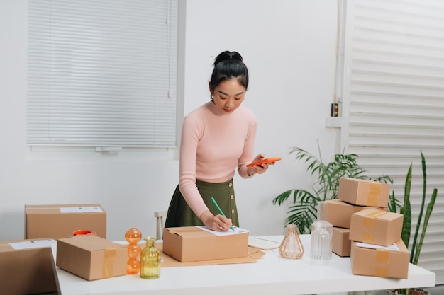 Young beautiful woman checking a parcel with smiling look happy with her job