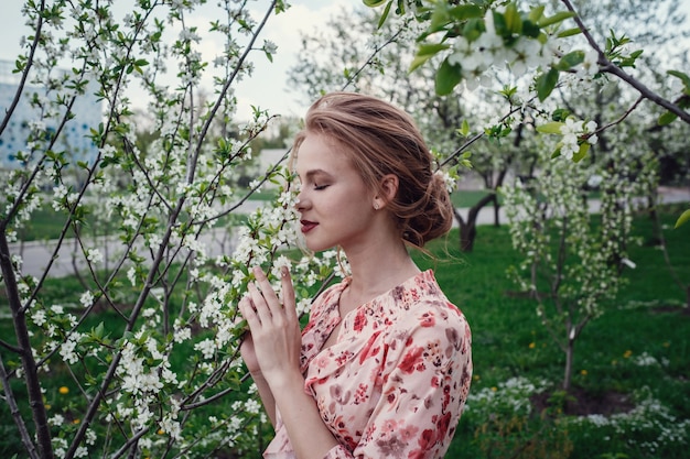벚꽃이 만발한 정원에서 젊은 아름 다운 여자.