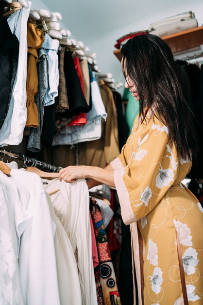 Young beautiful woman choosing clothes in her wardrobe at home