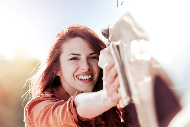 屋外で車を掃除する若い美しい女性