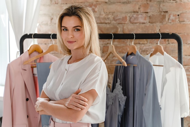 Young beautiful woman and clothing rack with different outfits