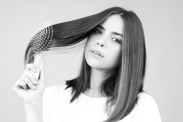 Young beautiful woman combing hair Hair Care Beautiful brunette woman hairbrushing hair with hairbru