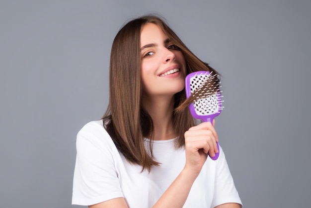 Young beautiful woman combing hair Hair Care Beautiful brunette woman hairbrushing hair with hairbru