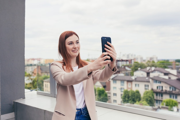 Young beautiful woman corresponded on the phone smiling and dressed in a business suit