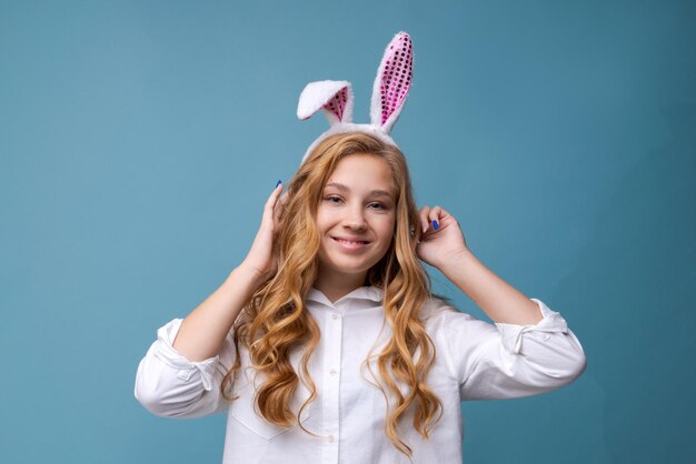 Young beautiful woman in cute easter bunny ears makes a normal gesture plays person