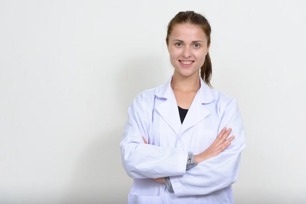 young beautiful woman doctor against white wall