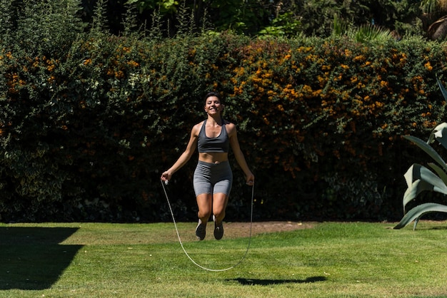 Young and beautiful woman doing gymnastics in the garden of her house