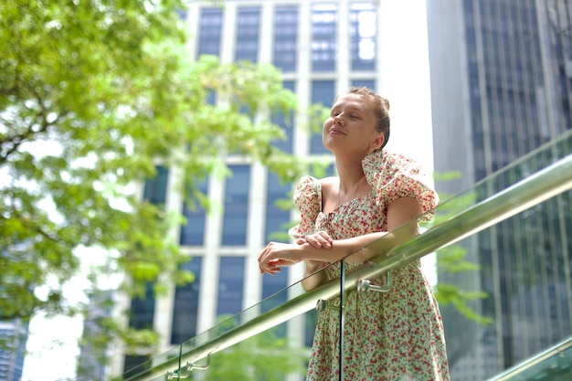 Young beautiful woman in dress walk in the city at spring or summer sunny day