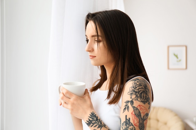 Young beautiful woman drinking coffee at home in morning