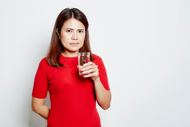 Young beautiful woman drinks water from a glass