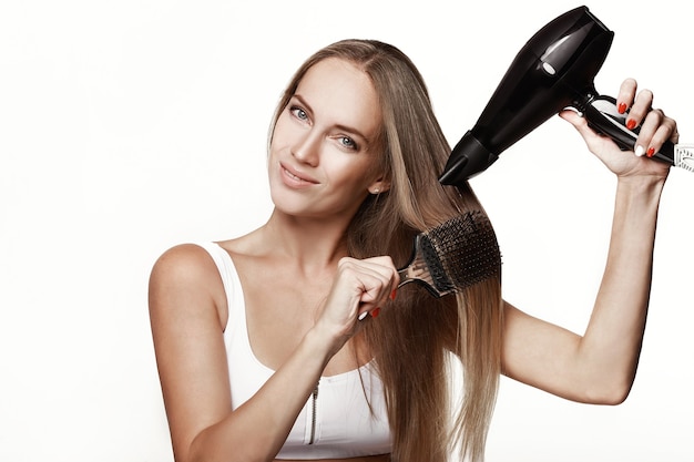 Young beautiful woman drying her hair