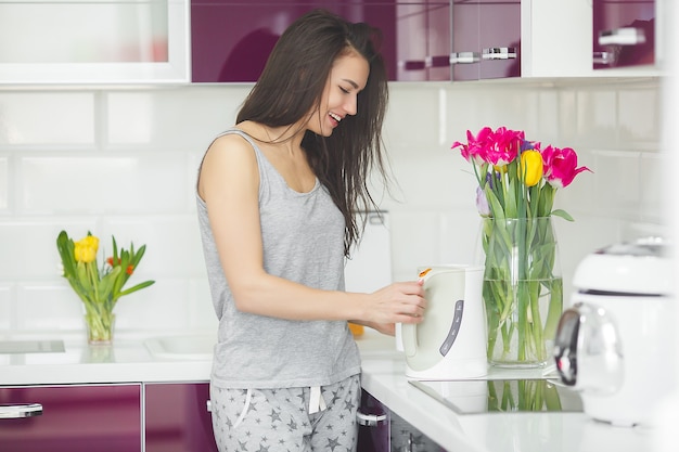 キッチンでコーヒーを飲んで早朝の若い美しい女性。新鮮な朝。ブレーシングドリンク。仕事の料金。目を覚ましている女性。