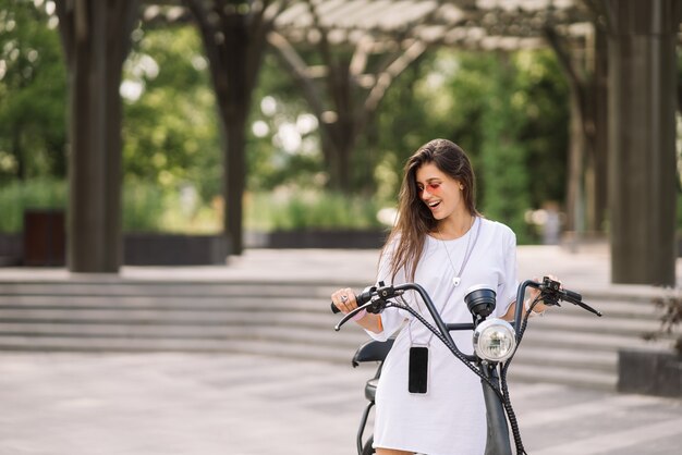 若い美しい女性と電動スクーターの生態学的輸送