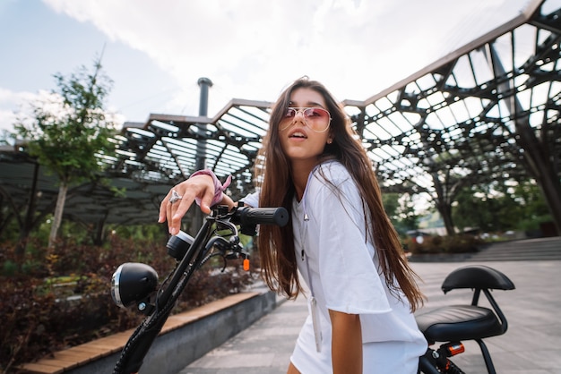 Foto giovane bella donna e un trasporto ecologico di scooter elettrico