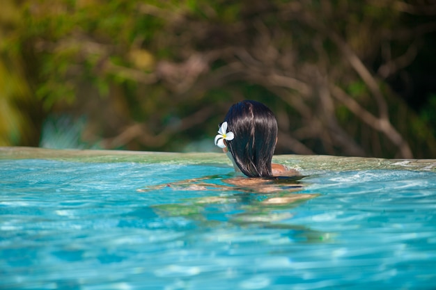 Young beautiful woman enjoying the luxury quiet swimmingpool