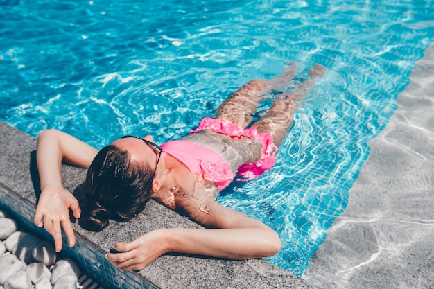 럭셔리 수영장에서 여름 휴가를 즐기는 젊은 아름 다운 여자