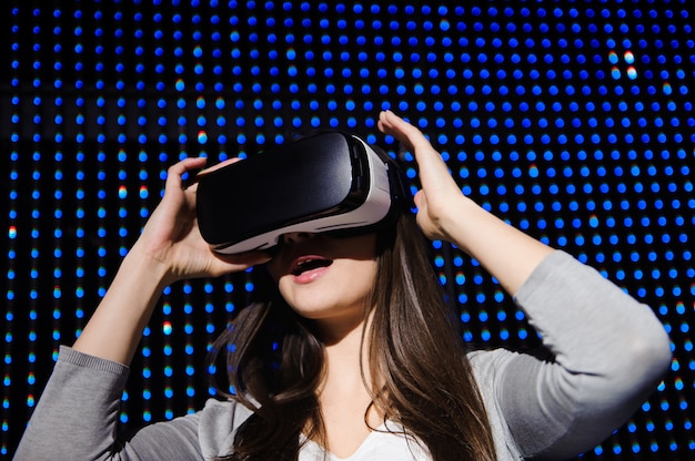 Young beautiful woman experiencing virtual reality glasses