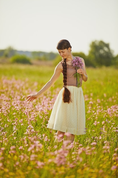 Young beautiful woman in a field with flowers