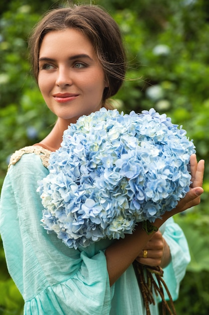 フィールドでアジサイの花を収集する若くて美しい女性の花屋