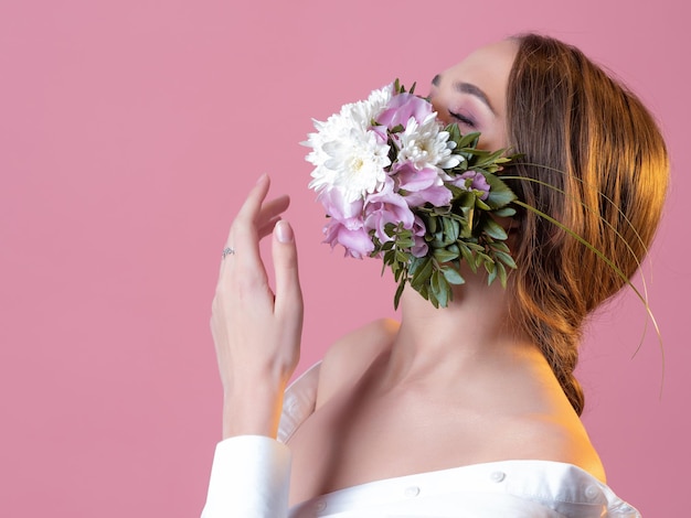 Young beautiful woman in a flower face mask spring and allergy concept portrait in the studio on a p...