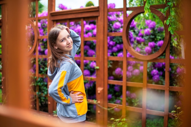 Young beautiful woman in the garden on the background of purple flowers