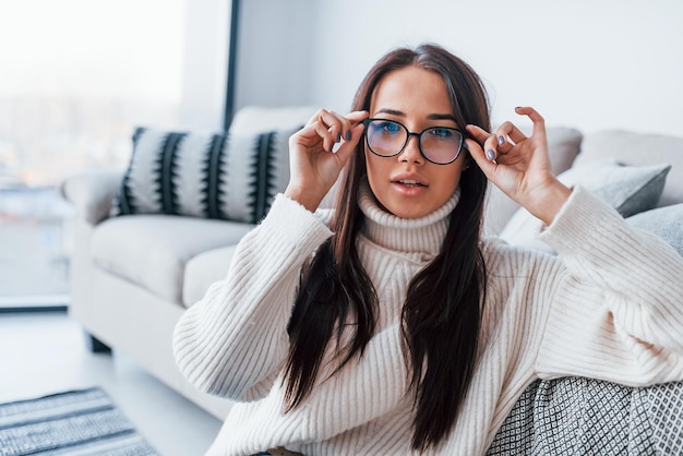 Young beautiful woman in glasses sitting at home alone.