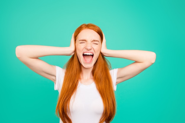 Young beautiful woman on a green background screaming