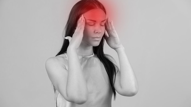 Young beautiful woman has headache isolated on gray background Exhausted girl portrait