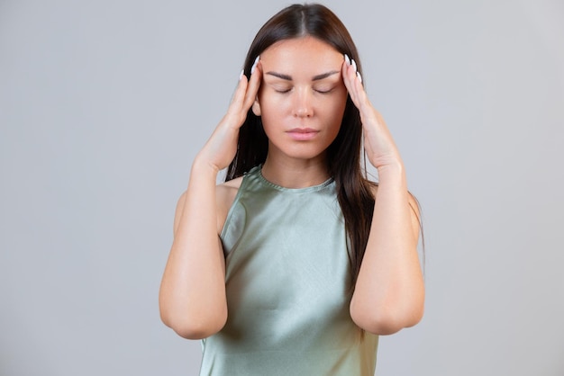 Young beautiful woman has headache isolated on gray background Exhausted girl portrait