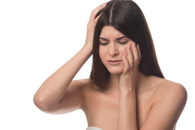 Photo young beautiful woman has headache, isolated on white background. exhausted girl portrait