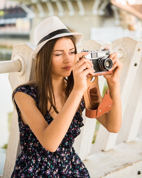 Young beautiful woman in hat is taking picture.