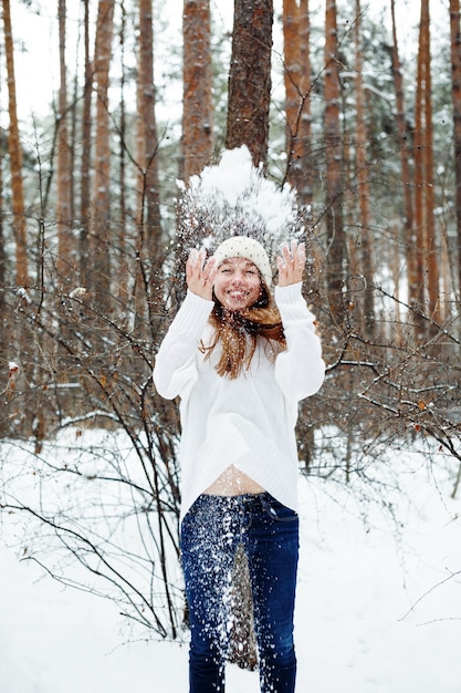 Young beautiful woman having fun in winter park. Christmas holidays, winter vacation concept.