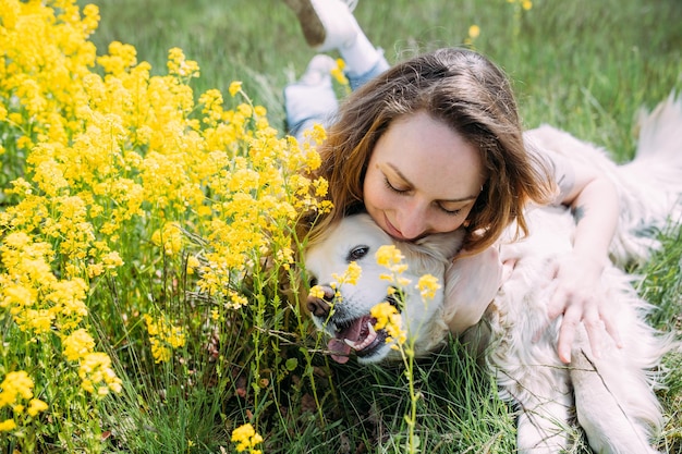 若くてきれいな女性と夏に楽しんでいる彼女のゴールデンレトリバー犬