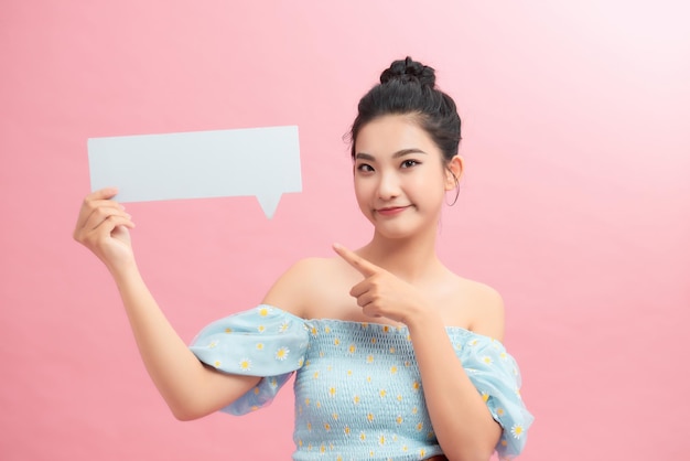 Young beautiful woman holding blank speech bubble with copy space for text