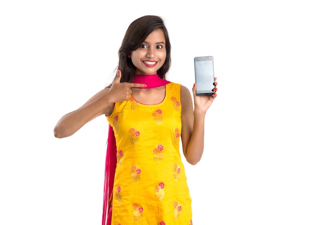 Young beautiful woman holding and showing blank screen smartphone or mobile or tablet phone on a white.